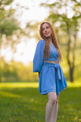 Beautiful Girl with long hair posing in sunbeams in park