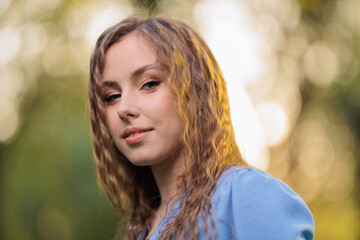 Naklejka premium Beautiful Girl with long hair posing in sunbeams in park