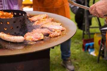 Outdoor barbecue with grilling meat and sausage on open fire