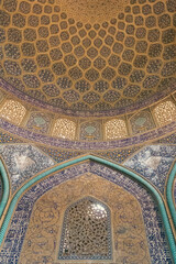 Intricate Islamic tilework and Quranic inscriptions inside a historic mosque in Esfahan, Iran, showcasing Persian architecture and spiritual artistry.