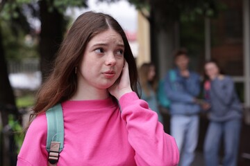 Teenage girl suffering from bullying at school, selective focus