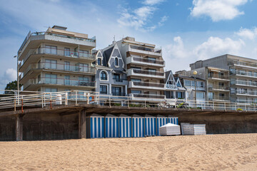 La Baule beach in Brittany, France, with its blue and white beach huts, and the houses just behind them