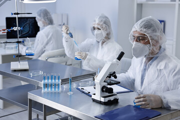 Scientists wearing protective suits while working in laboratory