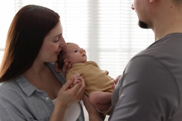 Parents with their cute newborn baby indoors