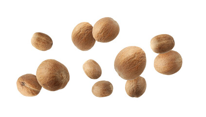 Aromatic nutmeg seeds falling on white background