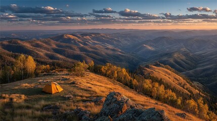 Fototapeta premium A tent perched atop a mount, offering panoramic views of valleys and distant peaks during twilight