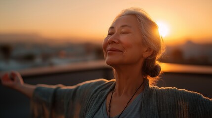 Elderly woman enjoying a sunset on a rooftop in a city during golden hour