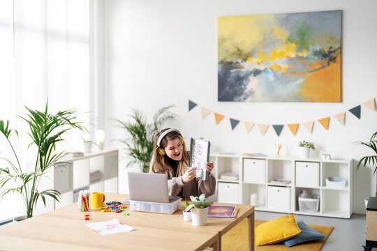 A teacher is leading an online class, using a whiteboard to explain emotions. She's engaging with students remotely, making learning fun and interactive.