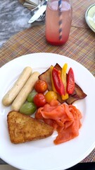 Colorful vegetables, smoked salmon, sausages, and golden hashbrown presented artfully, perfect dish for tourists enjoying healthy bites near tourist attraction with vibrant street energy.