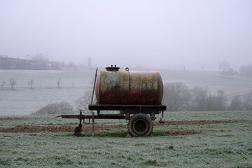 Wassertank auf Feld im Winter bei diesigen Wetter mit Raureif und Bodenfrost - Stockfoto