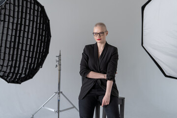 Confident Woman in Professional Attire Sitting in Photography Studio. Female cancer survivor....