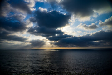 Vast Ocean at Sunset with Sun Rays Breaking Through Clouds