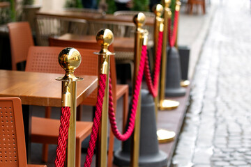 A gold fence post with red rope.
