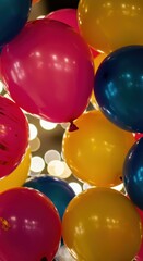 Vibrant balloons in shades of pink, blue, and yellow create a cheerful atmosphere at a celebration