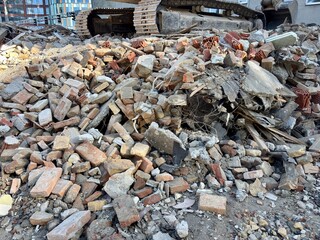  Large pile of construction rubble and debris with an excavator track visible, concept of demolition, waste management, urban renewal