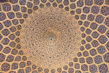Exquisite ceiling of the Sheikh Lotfollah Mosque in Esfahan, Iran, featuring mesmerizing geometric patterns and symmetrical Persian artistry.