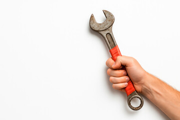 His hand holds a rusty wrench tightly. Space for text.