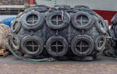 Yokohama harbor fender made of recycled tires guards a ship during docking operations.