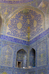 Intricate Islamic tilework and Quranic inscriptions inside a historic mosque in Esfahan, Iran, showcasing Persian architecture and spiritual artistry.