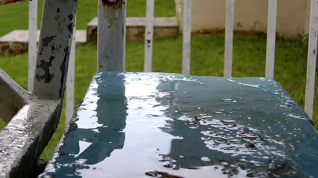 Gotas de agua cayendo desde un balc&oacute;n durante un momento de lluvia. Las peque&ntilde;as gotas descienden una tras otra, reflejando la luz y creando una escena sencilla que captura el ambiente h&uacute;medo y tranqu