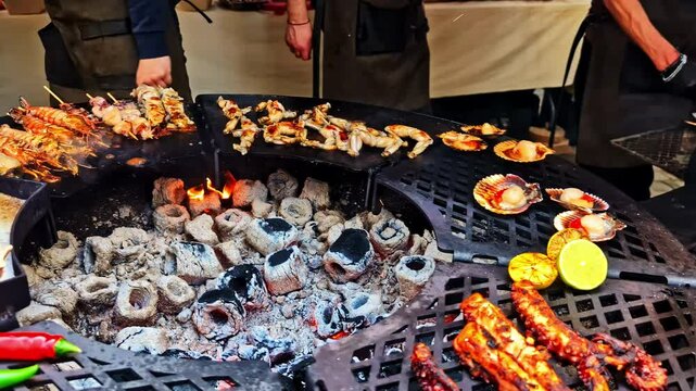 Grilled seafood including octopus and scallops on round coal-fired market grill