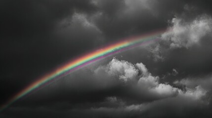 Fototapeta premium A monochromatic picture of a cloudy sky with a rainbow centered within it, appearing as two rainbows