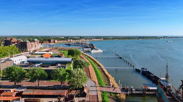 Flying over the museum Batavialand in Lelystad, the Netherlands. Beautiful green lakefront and peaceful waterscape from drone footage.