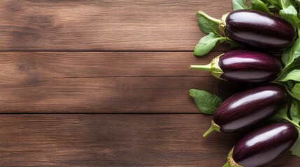 A cluster of fresh eggplants adorned with vibrant green leaves elegantly displayed on a wooden table, showcasing their rich color and inviting healthy cooking options.