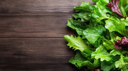 A vibrant mix of fresh green salad leaves displayed over a rustic wooden surface, embodying the essence of healthy eating and the pleasure of incorporating fresh ingredients into meals.