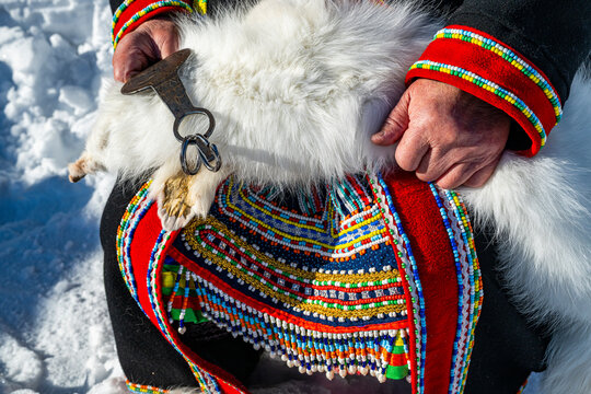 Traditional dressed Evenki woman with dead snow foxes in her hand, Tura, Krasnoyarsk Krai, Evenki state, Russia