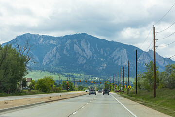 The foothills of Boulder shimmer with green under a moody summer sky, as distant lightning...