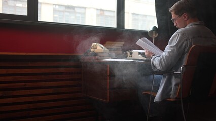 Male novelist deep in creative thought, vintage office with typewriter and papers in cinematic soft...