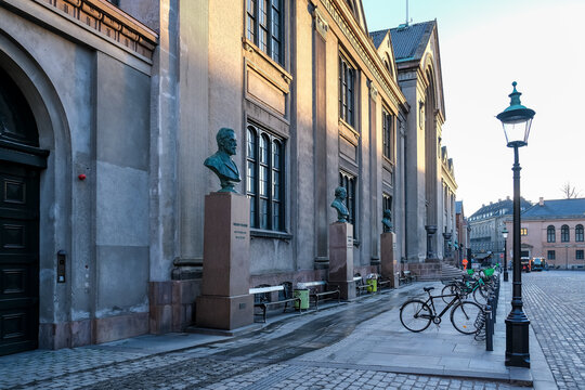 View of Frue Plads' entrance to Copenhagen University, framed by bronze busts of scholars, marking the historic core of Denmark's academic elite since 1479.