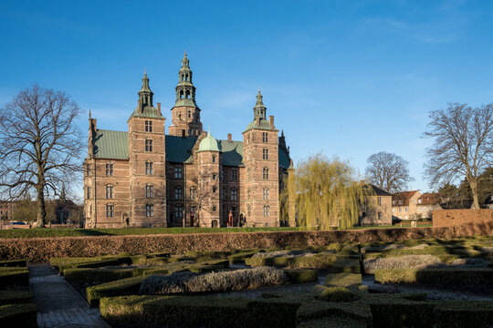 View of Rosenborg Slot from Kongens Have, showing the castle framed by tree-lined paths and floral gardens, highlighting its regal presence in Copenhagen's oldest royal park.