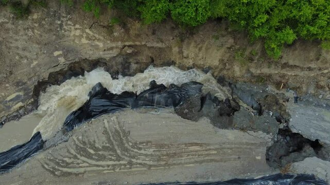 Aerial footage of the place where the Corund River enters the salt mine in Praid, Harghita County - Romania. The hole where the water floods into the Praid salt mine