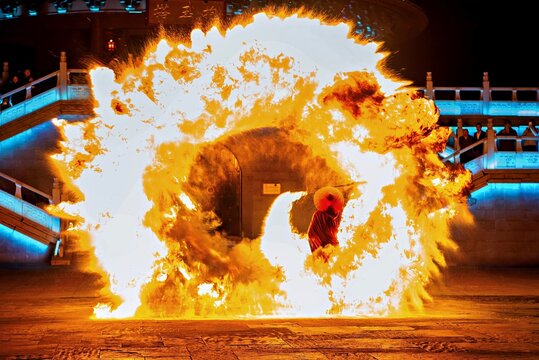 A performer wielding a fire staff surrounding himself with a ball of fire at WuNvZhou Resort, Wuyuan County, Shangrao, Jiangxi Province, China