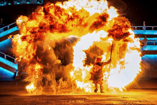 A performer wielding a fire staff surrounding himself with a ball of fire at WuNvZhou Resort, Wuyuan County, Shangrao, Jiangxi Province, China