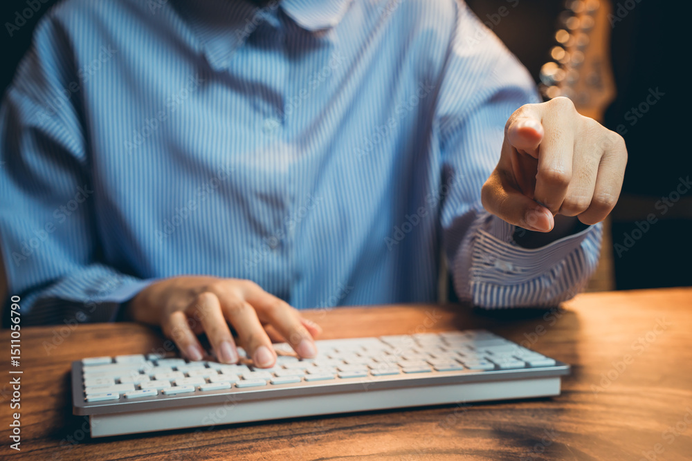 Poster close-up of a business professional pointing at a computer keyboard while working in a modern office