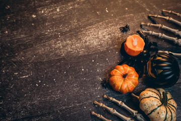 Halloween flat lay. Halloween Decorations with Pumpkins, Candles, Skeletons and Spiders on Rustic...