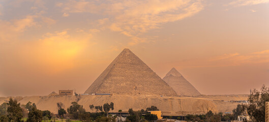 View of the Giza Pyramids from rooftop terrace during golden hour, Giza, Cairo, Egypt, Africa