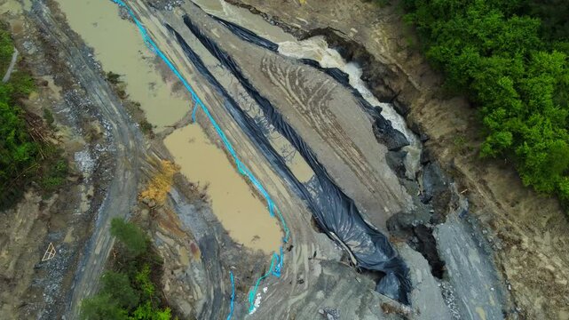 Aerial footage of the place where the Corund River enters the salt mine in Praid, Harghita County - Romania. The hole where the water floods into the Praid salt mine