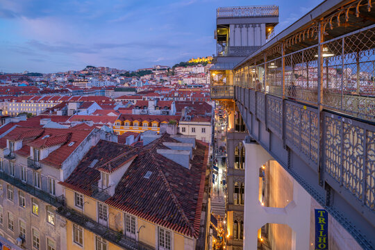 View of city rooftops and Santa Justa Lift from Carmo Archaeological Museum at dusk, Lisbon, Portugal, Europe