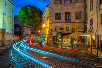View of cafe and bar with trail lights at dusk in the Alfama District, Lisbon, Portugal, Europe