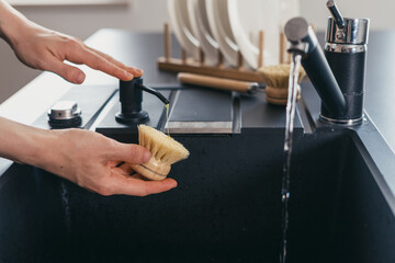 Modern kitchen sink with black countertop and stylish faucet in clean space