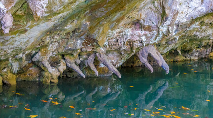 Stalagtites almost touching the water  during high tide in the famous bat cave (Gua Kelawar), (Langkawi, Kedah, Malaysia