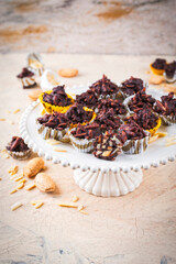Artisan handcrafted fine dark chocolate pralines with crushed almonds served as close-up on a cake plate