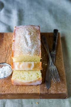 Sliced lemon poundcake on a cutting board with powdered sugar 