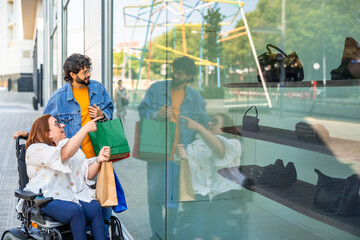 Friends window shopping, choosing bags and shoes, disabled woman on wheelchair