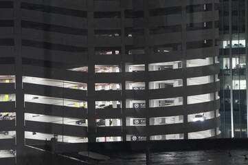 Modern Multi-Level Parking Garage at Night with Visible Cars