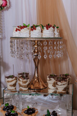 Elegant Dessert Display with tiered cake stand and individual tiramisu servings at a luxurious event, featuring gold accents, crystal details, and a soft background